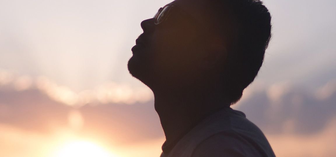 Man standing in front of sunset