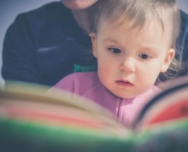 Parent reading book to young child