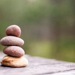 Four pebbles stacked on table outdoors