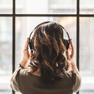 Woman listening to music in front of window