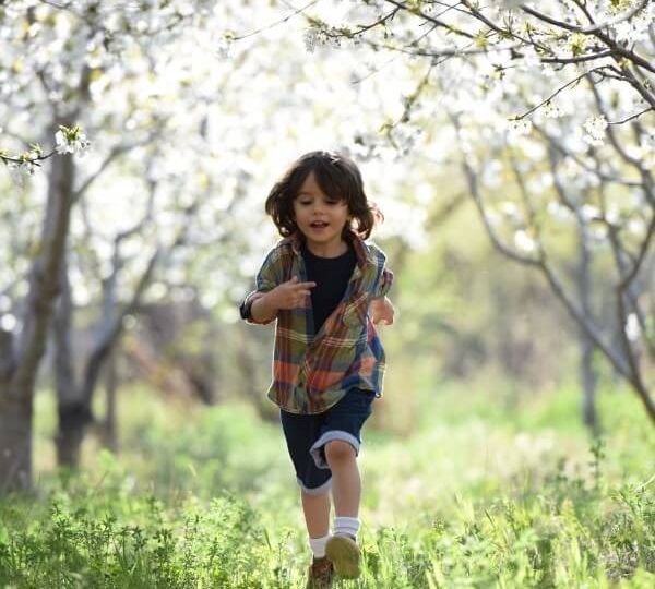 Happy young boy running through or