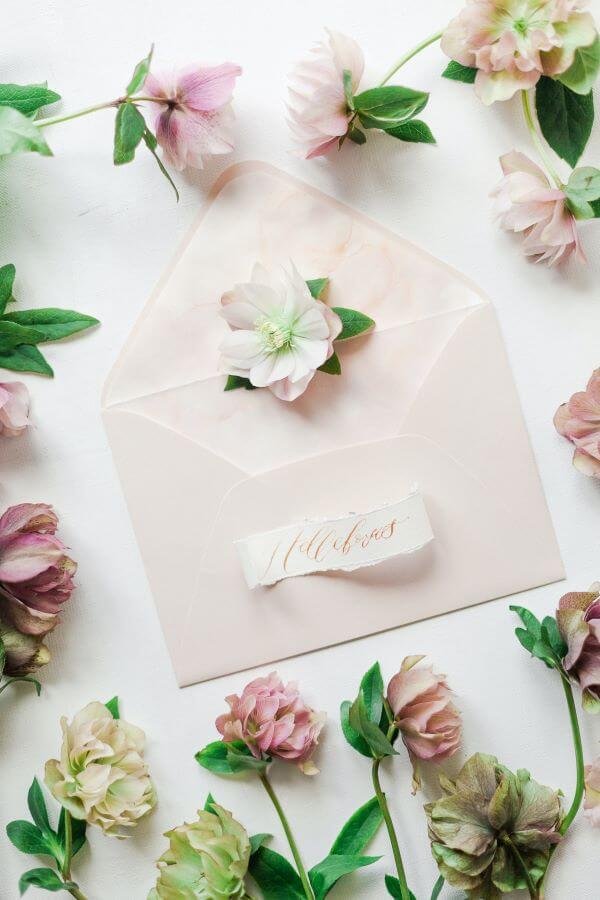 Open envelope surrounded by pink flowers