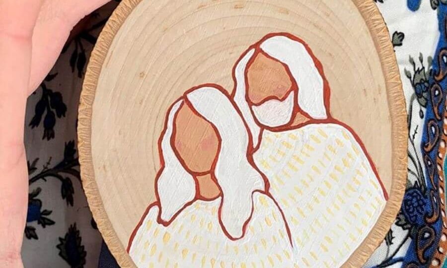 Two white figures painted on wooden disk