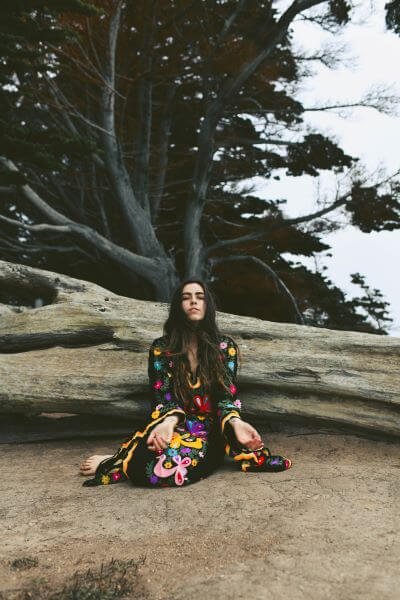 Marcie sitting on the ground in front of a large tree