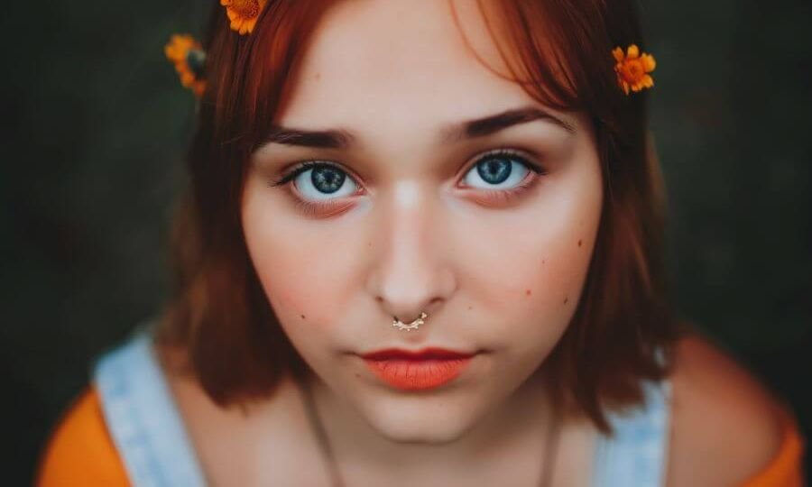 Girl with orange flowers in her hair looking at camera