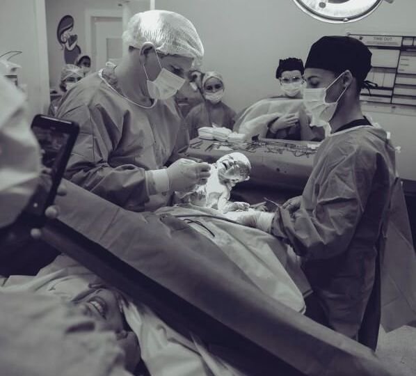 Black and white photo of doctors and nurses performing a c-section